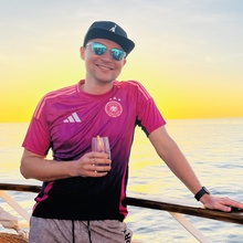 Adrian Schöne, underwater photographer, smiling at sunset over the ocean